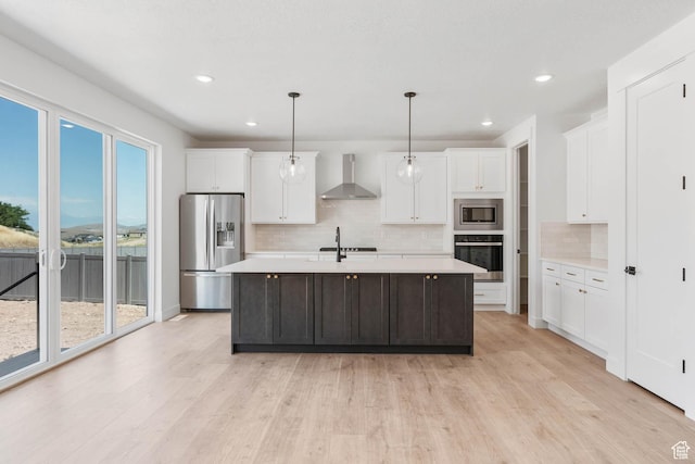 1203 Crest Dale Ln, Santaquin, UT 84655 - kitchen with wall chimney exhaust hood, light wood-style floors, light countertops, and stainless steel appliances