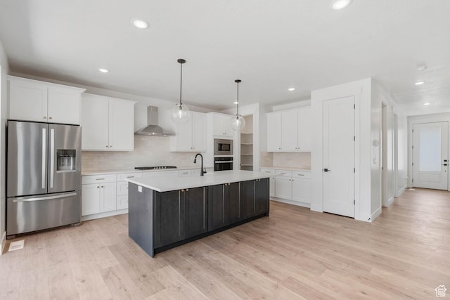 1203 Crest Dale Ln, Santaquin, UT 84655 - kitchen with light countertops, light wood-style flooring, wall chimney exhaust hood, appliances with stainless steel finishes, and white cabinetry