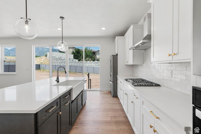 1203 Crest Dale Ln, Santaquin, UT 84655 - kitchen featuring a sink, freestanding refrigerator, white cabinetry, wall chimney exhaust hood, and gas cooktop