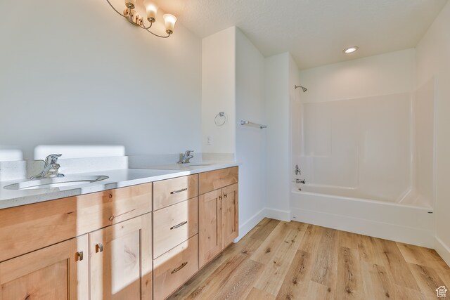 112 E 730 N Unit 102, Tooele, UT 84074 - bathroom with tub / shower combination, hardwood / wood-style flooring, and dual bowl vanity