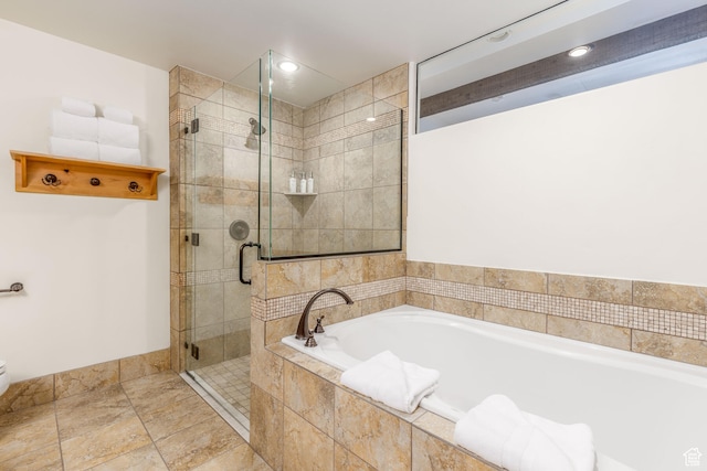 bathroom featuring shower with separate bathtub and tile floors