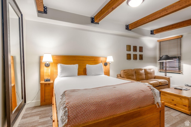 bedroom featuring light carpet and beam ceiling