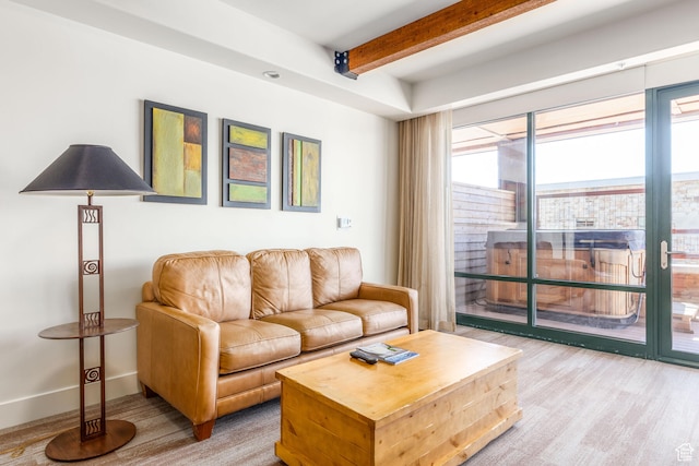 carpeted living room featuring beam ceiling