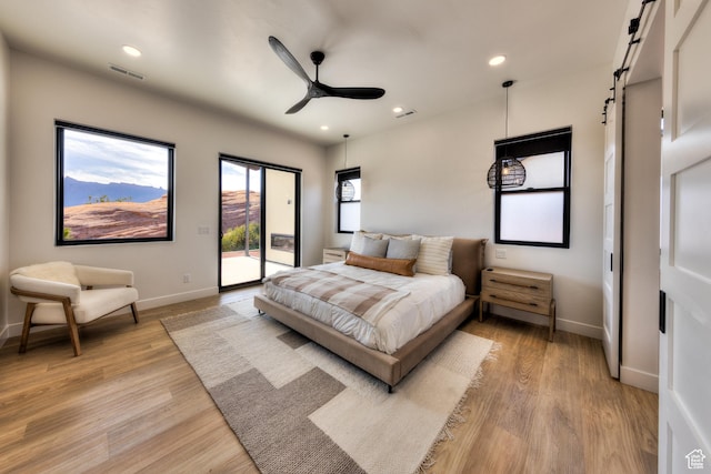 2194 Salida Del Sol, Moab, UT 84532 - bedroom with light wood-type flooring, baseboards, a barn door, visible vents, and access to exterior