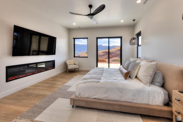 2194 Salida Del Sol, Moab, UT 84532 - bedroom with recessed lighting, access to exterior, wood finished floors, and a glass covered fireplace