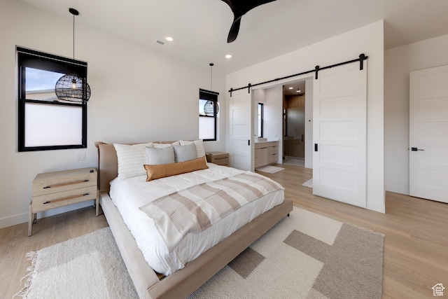2194 Salida Del Sol, Moab, UT 84532 - bedroom featuring light wood-type flooring, a barn door, and recessed lighting