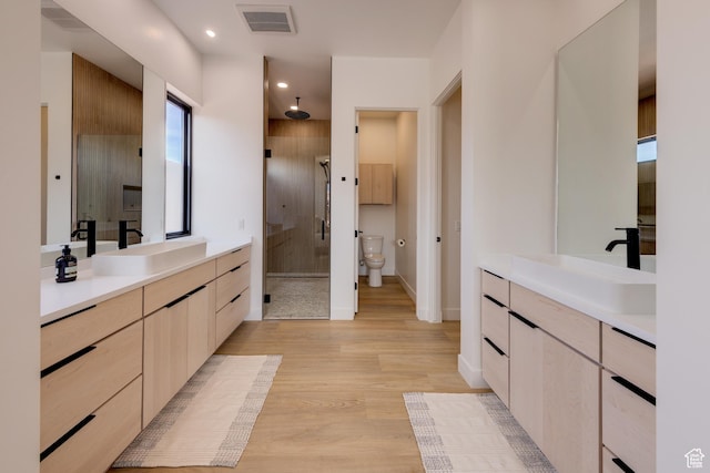 2194 Salida Del Sol, Moab, UT 84532 - bathroom with visible vents, a sink, a stall shower, and wood finished floors