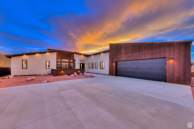 modern home featuring an attached garage, driveway, and stucco siding