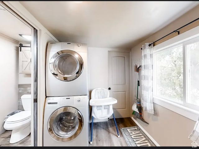 27 W 150 S, Garden City, UT 84028 - washroom with a barn door, light hardwood / wood-style floors, and stacked washer and dryer