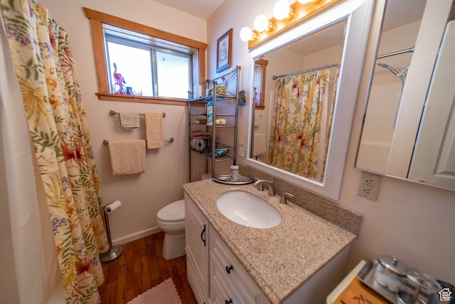 bathroom with a shower with curtain, wood-type flooring, vanity, and toilet