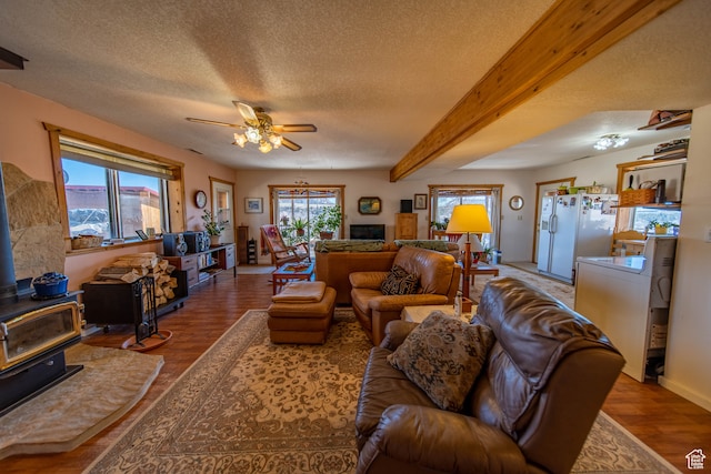 living room featuring a wealth of natural light, wood-type flooring, and a wood stove