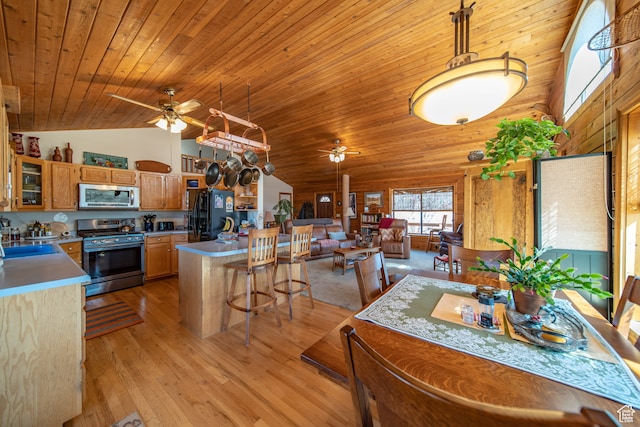 kitchen featuring stainless steel appliances, ceiling fan, pendant lighting, and light wood-type flooring