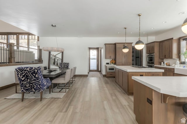 1905 E Kings Peak Cir, Heber City, UT 84032 - kitchen with decorative light fixtures, light countertops, light wood-style flooring, appliances with stainless steel finishes, and a kitchen island