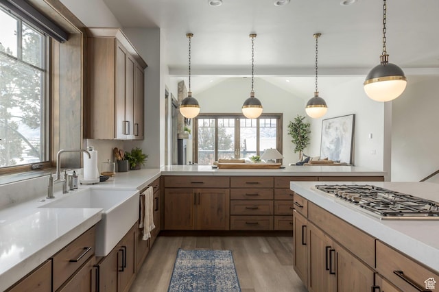 1905 E Kings Peak Cir, Heber City, UT 84032 - kitchen featuring a sink, light wood-style floors, light countertops, decorative light fixtures, and stainless steel gas stovetop