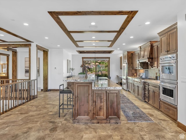 1707 E Kings Peak Cir N, Heber City, UT 84032 - kitchen with stainless steel appliances, a center island with sink, a breakfast bar, recessed lighting, and light stone counters