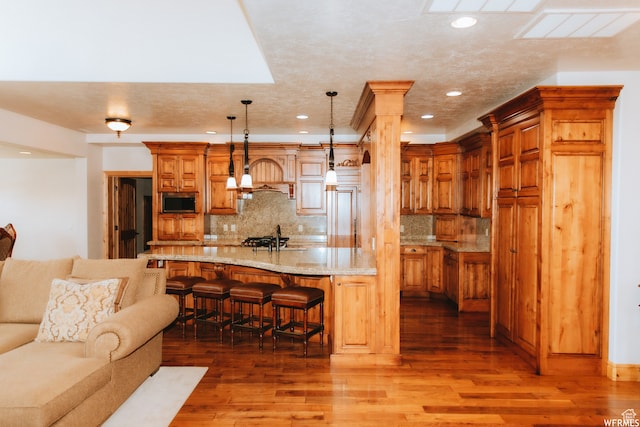493 N 12500 W, Bluebell, UT 84007 - kitchen with hardwood / wood-style flooring, tasteful backsplash, and a breakfast bar