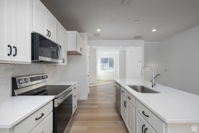 4119 S Winder Ward Dr E Unit 3-106, Millcreek, UT 84124 - kitchen with appliances with stainless steel finishes, a sink, light wood-type flooring, white cabinets, and tasteful backsplash