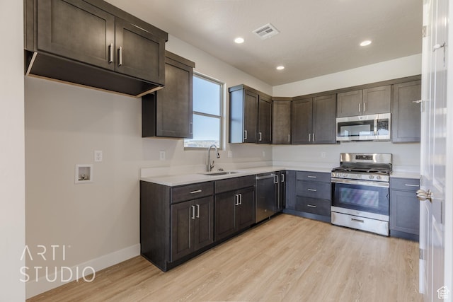 2086 W 320 S, Hurricane, UT 84737 - kitchen with appliances with stainless steel finishes, a sink, dark brown cabinets, light wood-type flooring, and light countertops