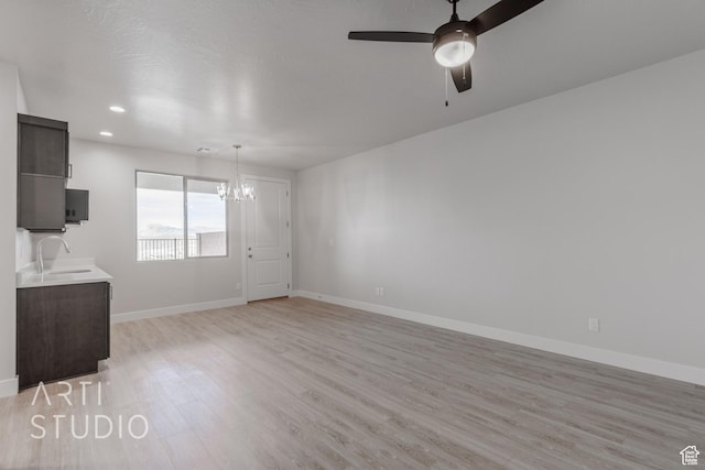 2086 W 320 S, Hurricane, UT 84737 - unfurnished living room featuring a sink, a chandelier, light wood finished floors, baseboards, and ceiling fan