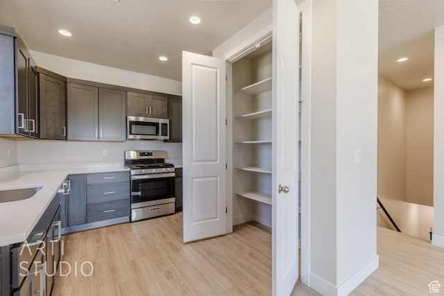 2086 W 320 S, Hurricane, UT 84737 - kitchen featuring appliances with stainless steel finishes, light wood finished floors, dark brown cabinetry, light countertops, and recessed lighting