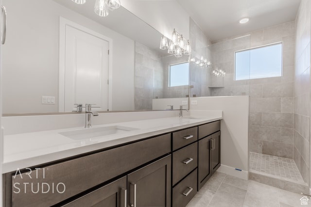 bathroom featuring vanity, a tile shower, and tile patterned flooring