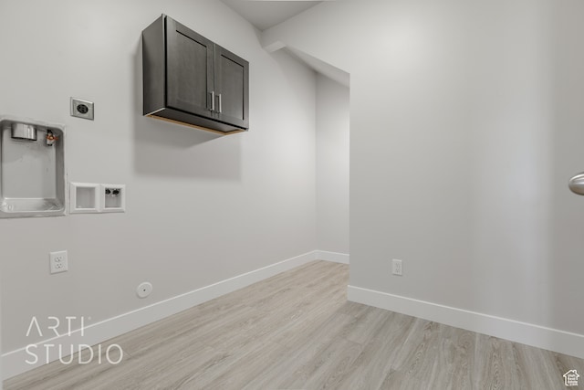 laundry room with washer hookup, hookup for an electric dryer, gas dryer hookup, cabinets, and light hardwood / wood-style floors
