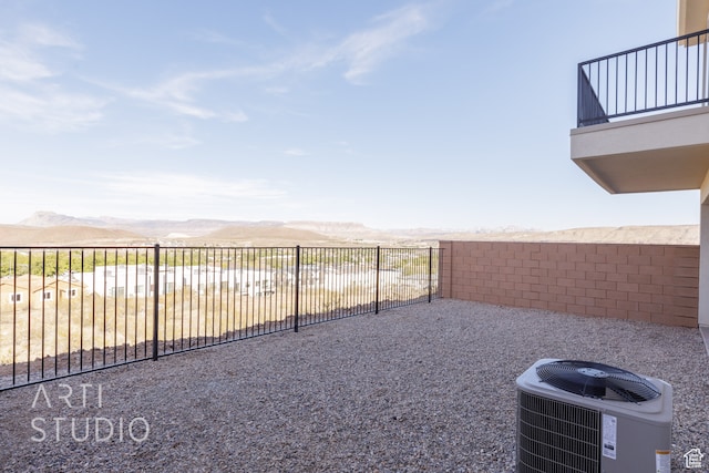 view of yard with a mountain view, central AC, and a balcony