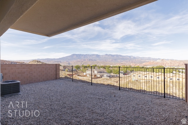 view of yard featuring a mountain view and central AC unit