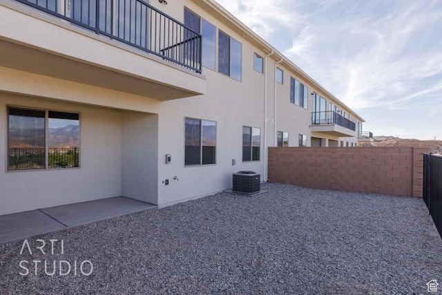 view of side of home featuring a balcony, a patio area, and central AC unit