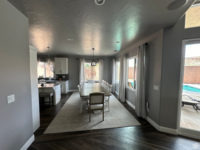 dining area featuring baseboards, a textured ceiling, and dark wood-style floors