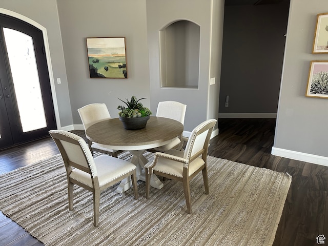 dining space featuring dark wood-style floors and baseboards