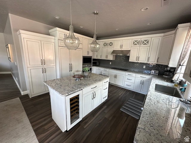 kitchen with a sink, wine cooler, stainless steel oven, black electric cooktop, and paneled built in refrigerator