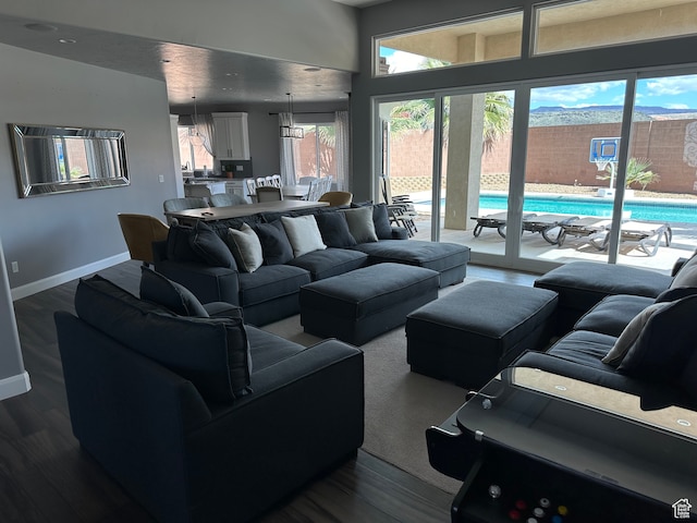 living room with baseboards and dark wood-style flooring