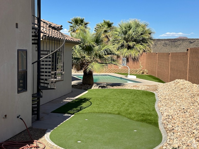 view of yard featuring a patio area, a fenced in pool, and a fenced backyard