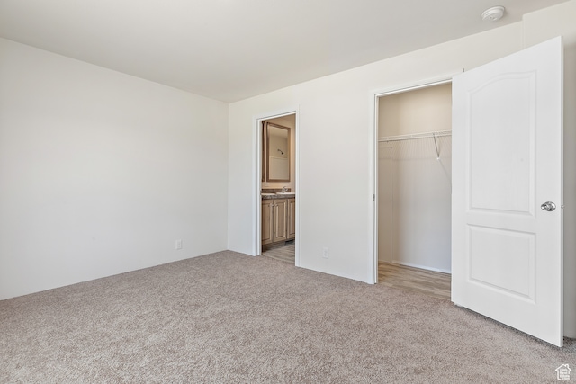 750 E 400 N Unit 220, Mount Pleasant, UT 84647 - unfurnished bedroom with light colored carpet, a walk in closet, ensuite bathroom, and a closet