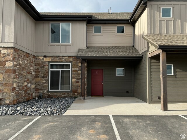 140 W 150 S Unit I32, Garden City, UT 84028 - exterior space featuring stone siding, a shingled roof, and board and batten siding