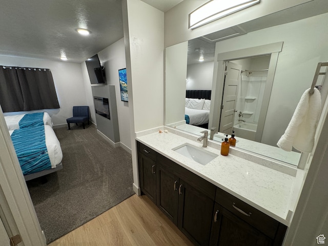 140 W 150 S Unit I32, Garden City, UT 84028 - ensuite bathroom with a glass covered fireplace, connected bathroom, vanity, wood finished floors, and baseboards