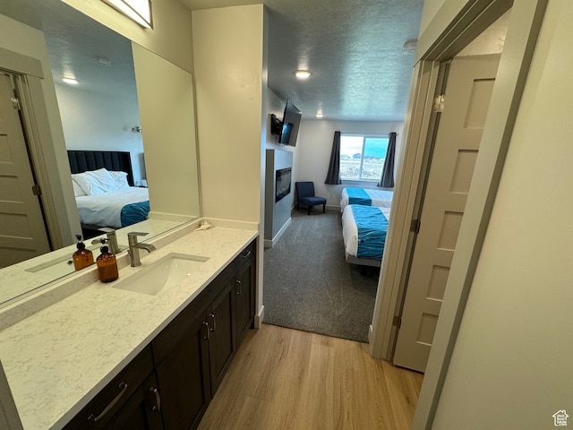 140 W 150 S Unit I32, Garden City, UT 84028 - ensuite bathroom featuring vanity, wood finished floors, a textured ceiling, and ensuite bathroom