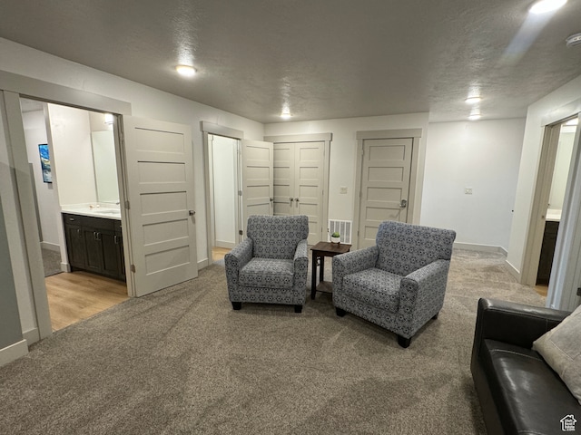 140 W 150 S Unit I32, Garden City, UT 84028 - living area featuring light carpet, visible vents, baseboards, and a textured ceiling