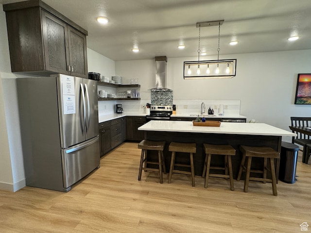 140 W 150 S Unit I32, Garden City, UT 84028 - kitchen with stainless steel appliances, light countertops, dark brown cabinetry, wall chimney range hood, and a kitchen island