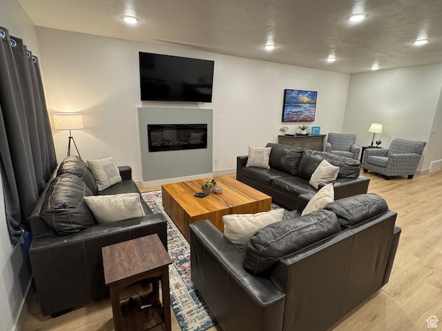 140 W 150 S Unit I32, Garden City, UT 84028 - living room with baseboards, recessed lighting, a glass covered fireplace, and light wood-style floors
