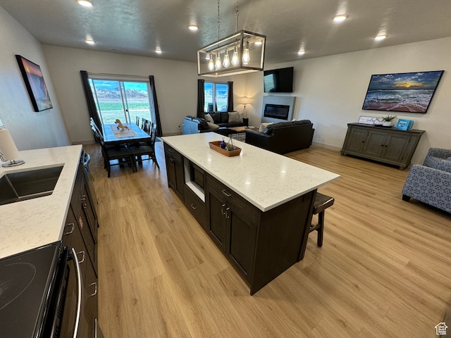 140 W 150 S Unit I32, Garden City, UT 84028 - kitchen featuring light stone counters, a center island, open floor plan, black electric range oven, and pendant lighting