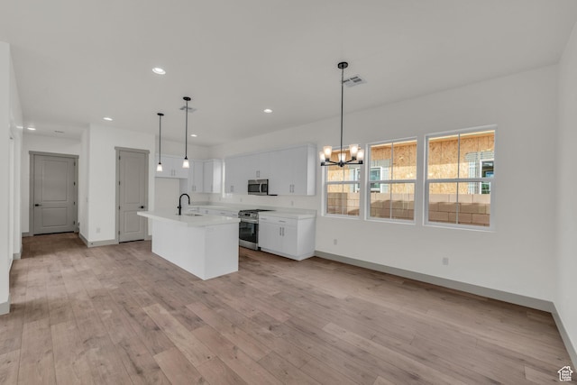 664 Pine Canyon Rd, St George, UT 84790 - kitchen featuring a kitchen island with sink, stainless steel appliances, white cabinets, decorative light fixtures, and sink