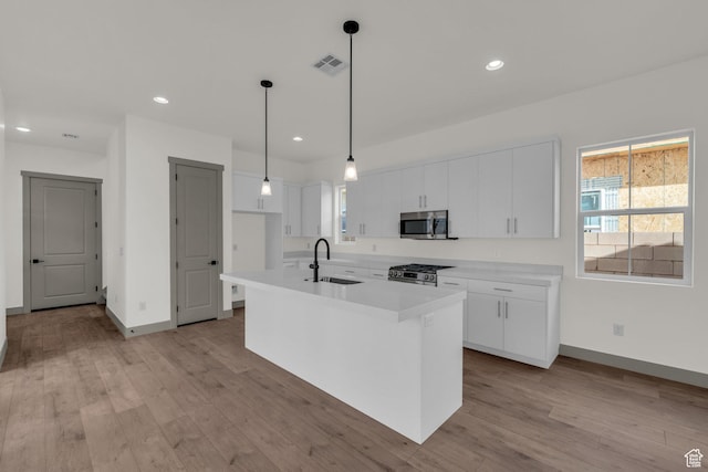 664 Pine Canyon Rd, St George, UT 84790 - kitchen with pendant lighting, an island with sink, white cabinetry, appliances with stainless steel finishes, and sink