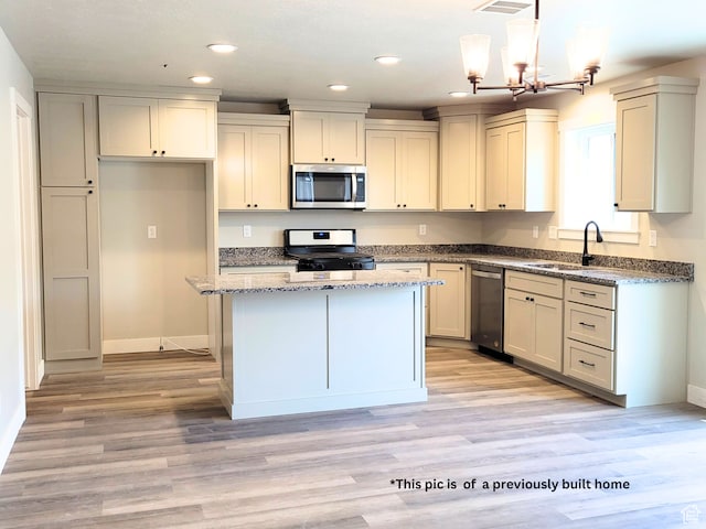 870 E 410 N Unit 159, Hyde Park, UT 84318 - kitchen with appliances with stainless steel finishes, a center island, sink, decorative light fixtures, and light hardwood / wood-style flooring
