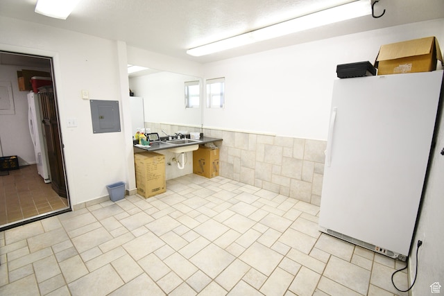 75 E 300 N, Glenwood, UT 84730 - kitchen featuring white fridge, light tile flooring, and tile walls
