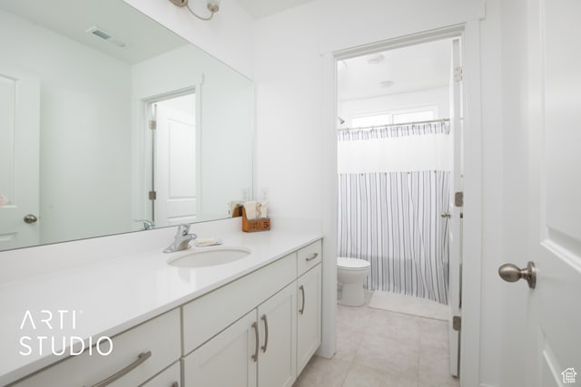 bathroom with vanity, tile floors, and toilet