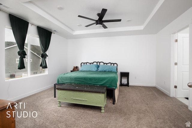 bedroom featuring carpet, ceiling fan, and a tray ceiling