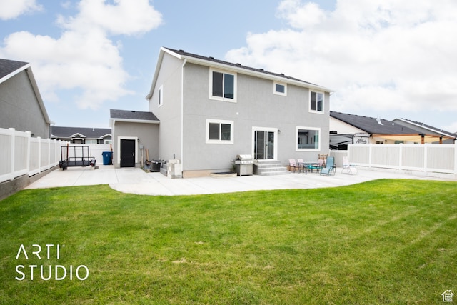 rear view of property with a yard and a patio area