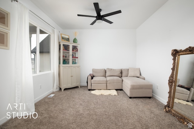 unfurnished living room with ceiling fan and carpet